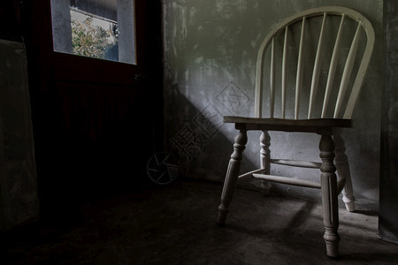 白色木椅在门外灯光下空的房间里站立有选择的焦点水泥建筑学老的图片