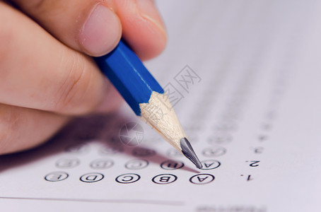 纸学生们手握铅笔在答题单和数学问上写有选择的作考试学校的生进行测以及知识图片