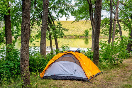 林中日出森湖边的橙色旅游帐篷林中野营橙子孤独图片