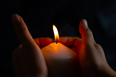 黑色的温暖红手保护蜡烛灯光防止黑底暗中的风图片
