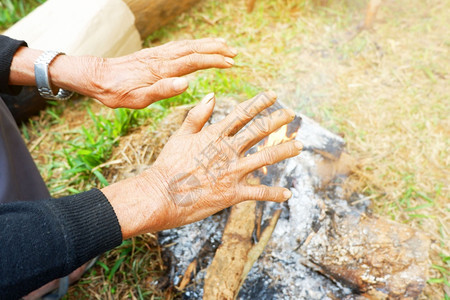 芒兰柯斯的手在冬天清晨从营火中烤水旅行草图片