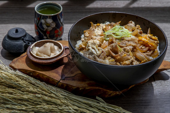 米可口日本猪肉饭碗配鸡蛋和洋葱Donburi在木桌日本菜风格上配有姜咸菜和绿茶麻布图片