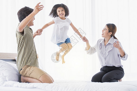 亚洲可爱的家庭在节假日过着快乐时光在家一起玩耍男人床父亲图片