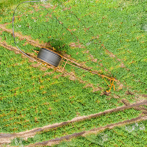 服务垂直空中与无人驾驶飞机对准可耕地灌溉的大型软管雷网进行垂直空中观察草甸图片