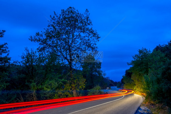 自然照亮夜间森林路上的长绕风道尾灰丝小路和深夜森林上的末光轨迹灯图片