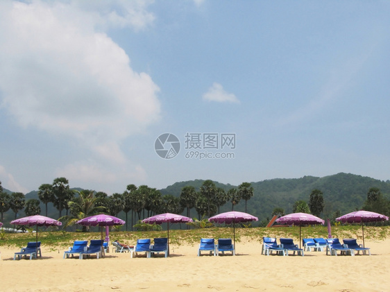 热带海滩上一排雨伞和防晒床泰夏天图片