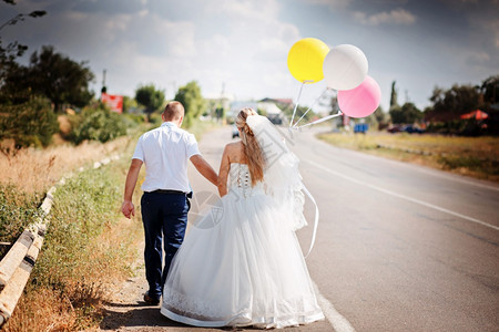 裙子成年人婚姻幸福的一对夫妇带着气球一起在路上走女士图片