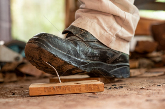 步木板保护工匠在建筑区用安全鞋踩板木上钉子的工人图片