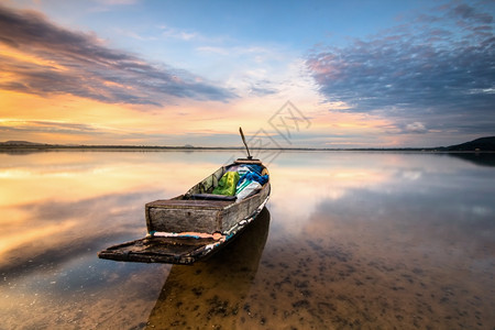 日落时在湖中捕鱼的渔船绿色老田园诗般图片