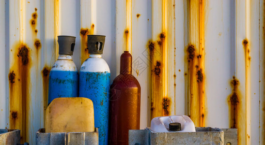 工业背景站在生锈容器前的旧压缩液化空气瓶子工业背景碳运动的压力图片