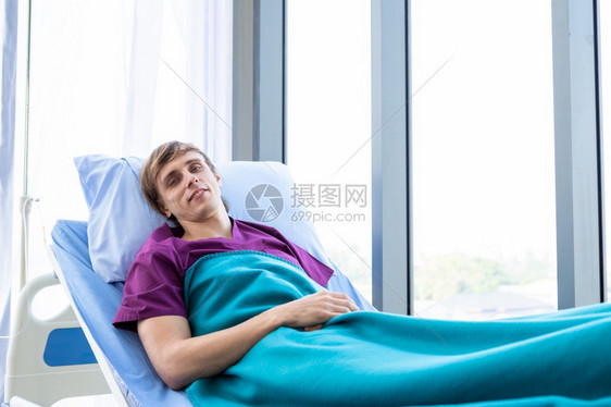 一名男病人焦虑的面部躺在房间里的床上在医院背景沮丧疾病痛苦图片