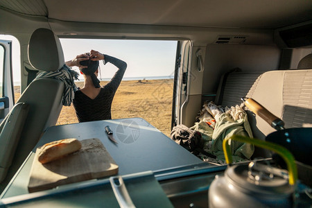 一位年轻女子在她的大篷车里吃早餐观察海滩的美景放松茶壶外部图片