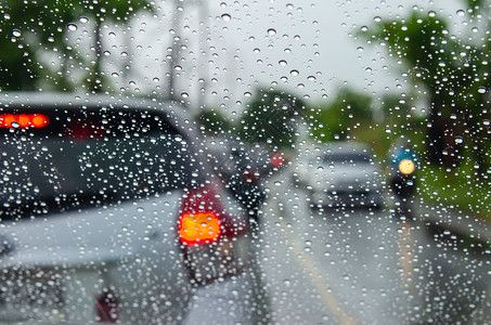 场景城市汽车的模糊图像窗边有水滴路下雨图片