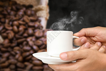 浓咖啡抽烟目的男人手握着白咖啡杯喝蒸汽或热饮喝着茶杯走剪条路图片