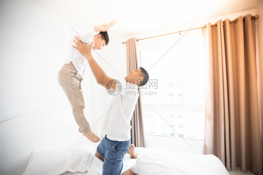 幸福的亚裔家庭儿子在卧室里玩乐和笑国内的爱快乐图片
