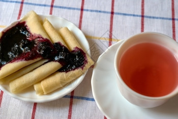 传统的煎饼加果酱和一杯红茶的煎饼盘子高架图片