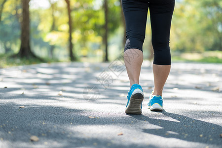 穿肌肉合身年轻的健女腿在户外公园散步女跑者在外面的路上跑步亚洲运动员在阳光下人行道上慢跑和锻炼运动健康和保概念图片