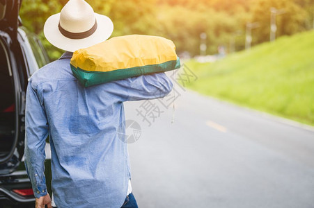 在农村旅行时游客背视沿路行走时带着袋子在路上挂走回观景人的生活方式和假期概念人持有和背包山地景的长假旅行远足目的地外部图片