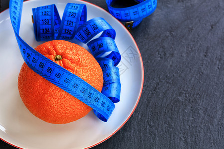 身体橙成熟的曼达林和美米位于白瓷板上健康饮食的概念是在盘子和仪表上减少体重时的健康饮食的概念胖厘米图片