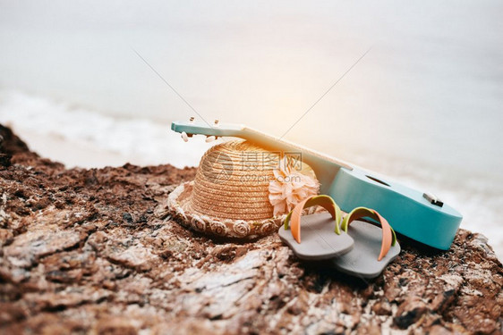 假期在Ukulele海滩度假的女伴沙鞋和海边岩石上的帽子热带和季节概念夏和日主题放松与自然主题闲暇粉彩图片