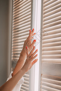太阳女手握着一个窗口的背景妇女醒来时在家中躺床上清晨早起睡醒阳光明媚的日间休息运动窗户图片