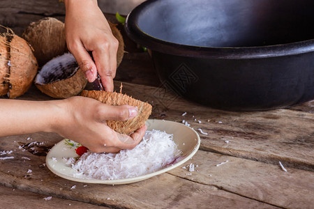 烹饪木头握手使用刮椰子的妇女把集装箱上做甜点和食物图片