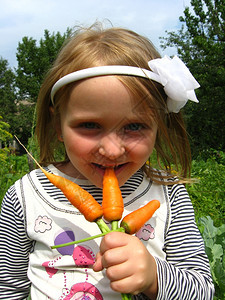 年轻的食物女孩咬成熟橙红胡萝卜的形象维他命图片