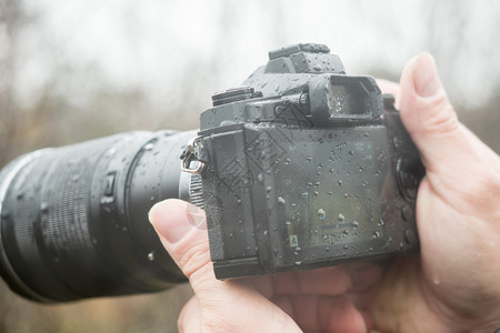 在职的安全秋天一个在雨中拿着摄像头的影师图片