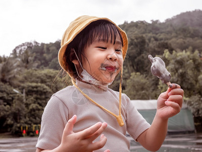 在炎热的夏日户外吃冰淇淋的小可爱女孩美丽的漂亮公园图片