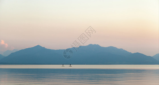 训练身体一对夫妇在湖边的日落时练习桨草嬉戏的图片