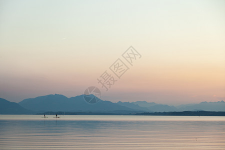 站立一对夫妇在湖边的日落时练习桨草合身老师图片