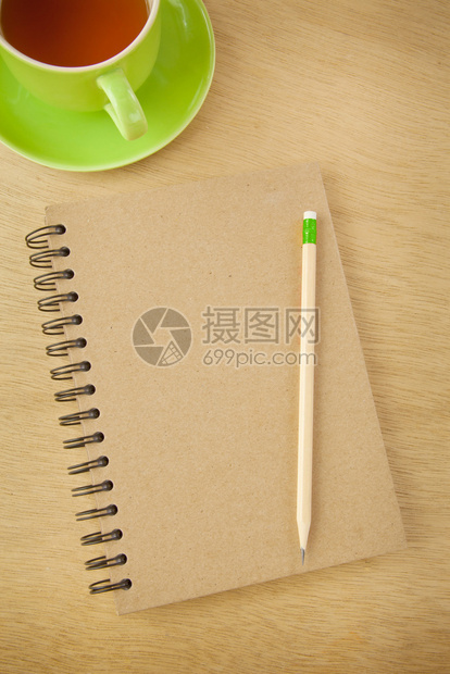 棕色的覆盖绿在木本背景上回收笔记本和木铅图片
