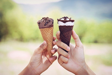 两手握着自然背景的冰淇淋锥甜点和平紫色的图片