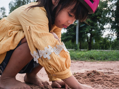晴天姐戴头盔的可爱小女孩在阳光明媚的夏日在公园里玩沙子骑自行车后休息会发展想象力和探索夏天图片