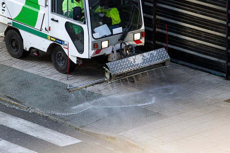 洗街道清洁机在人行上工作用加压水的维护或清洁概念理人行道上的洁机污垢运输图片