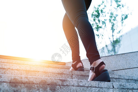 妇女走向成功商人青年妇在楼梯上向前迈步进女企业家