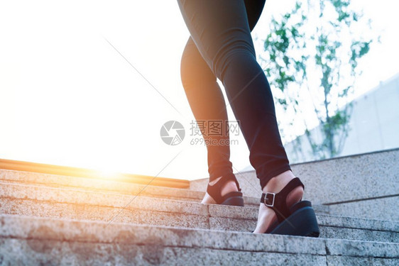 妇女走向成功商人青年妇在楼梯上向前迈步进女企业家正在走上楼梯爬人们图片