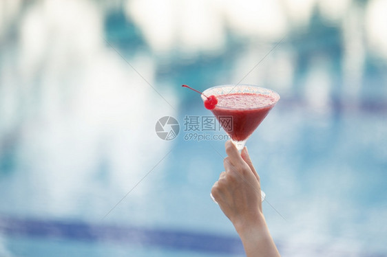 酒吧女人手握着杯鸡尾酒在泳池边缘柑橘一种图片