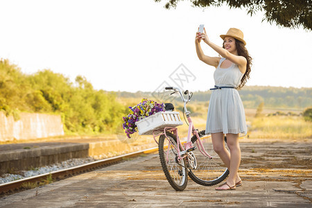 一种镇复制空间个美丽的年轻女子骑着自行车做拍图片