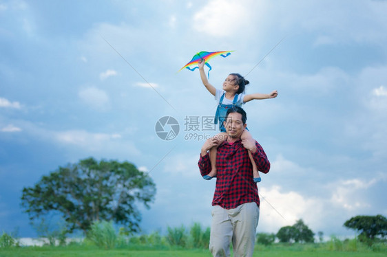 外部亚洲女孩和父亲带着风筝跑来去夏天在草地上快乐的亚洲女孩和父亲家庭绿色图片