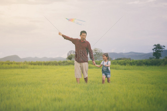 外部乐趣亚洲女孩和父亲带着风筝跑来去夏天在草地上快乐的亚洲女孩和父亲家庭图片