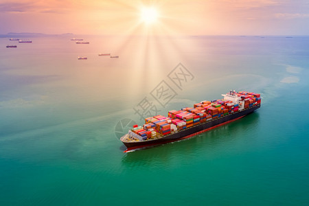 航行集装箱货物在公海上进行国际货运的商业贸易运输以及跨越多彩过程的背景空中观察而日落的风平浪景和日落之比色彩繁丽的过程背景空中观图片