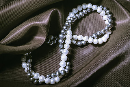比茹一种数字白珍珠和黑项链形式为丝绸贺礼卡上的无穷标志举行婚礼3月8日国际妇女节情人和母亲天自然珍珠项圈在丝绸背景上图片