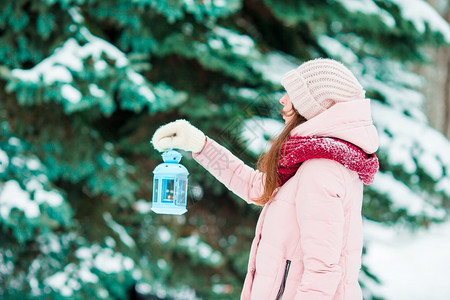 冬日美女在丽的冬雪日户外举着圣诞灯笼冬日在美丽的雪在户外举着圣诞灯笼步行衣服俏皮图片