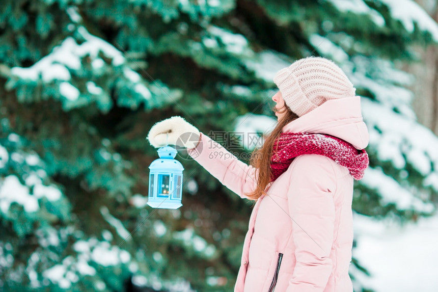 冬日美女在丽的冬雪日户外举着圣诞灯笼冬日在美丽的雪在户外举着圣诞灯笼步行衣服俏皮图片