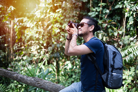 徒步旅行者冒险女亚洲男子背包和旅行者一起走在欢乐地森林上拍照假期概念旅行时间较慢图片