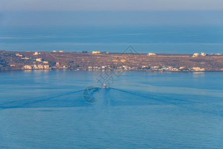 海岸一艘机动船在宁静的水中向码头漂浮乘空中观光船在日落帆上朝下海航视方向驶来浪漫的夏天图片