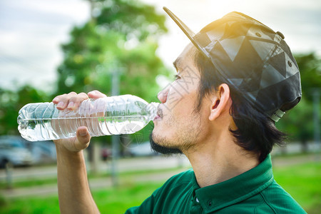 年轻的饮食男子在慢跑冲水和饮料之后可以用雨水和食物图片