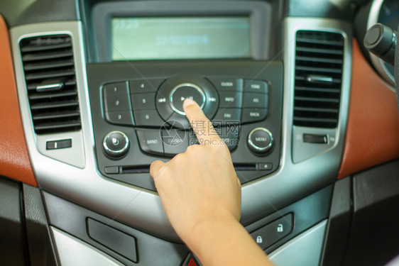 系统金属亚洲女在汽车收音机上监听乐的按键操舵图片