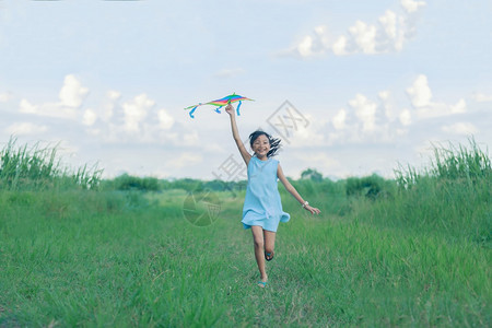 玩亚洲女孩带着风筝跑来去夏天在草地上欢乐的亚裔女孩随意子图片